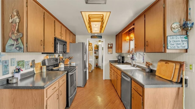 841 E Valencia St, Lakeland, FL 33805 - kitchen featuring stainless steel appliances, a sink, light wood-style floors, and dark countertops