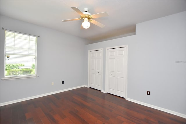 943 Hamilton Place Ln, Lakeland, FL 33813 - unfurnished bedroom with two closets, dark wood-type flooring, and ceiling fan