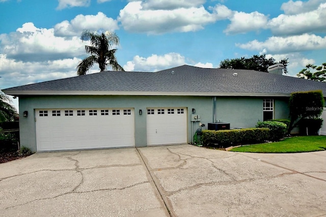 943 Hamilton Place Ln, Lakeland, FL 33813 - view of home's exterior with stucco siding, driveway, a garage, and roof with shingles