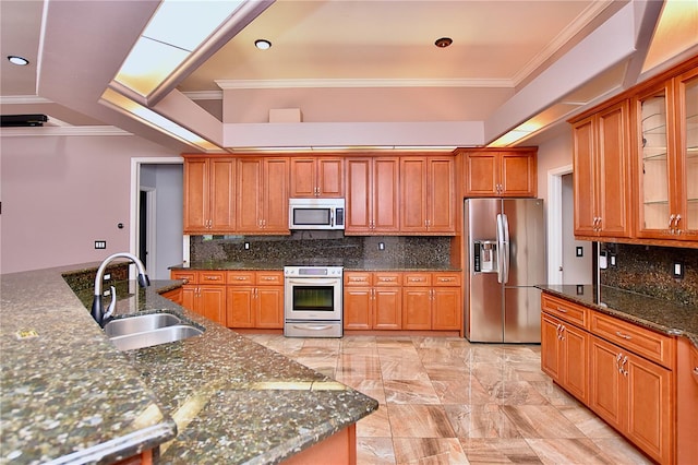 943 Hamilton Place Ln, Lakeland, FL 33813 - kitchen featuring stainless steel appliances, decorative backsplash, brown cabinets, dark stone countertops, and glass insert cabinets