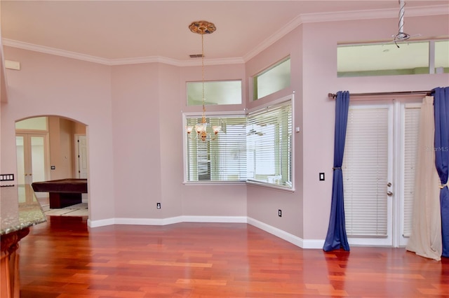 943 Hamilton Place Ln, Lakeland, FL 33813 - foyer entrance with arched walkways, wood finished floors, ornamental molding, and a chandelier