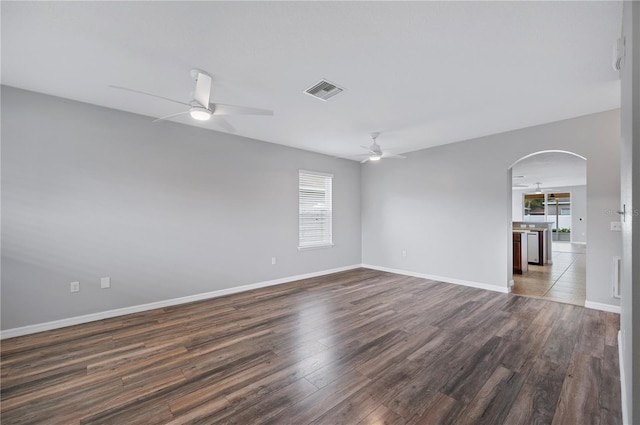 6819 Glenbrook Dr, Lakeland, FL 33811 - unfurnished room featuring ceiling fan, healthy amount of natural light, arched walkways, and dark wood finished floors