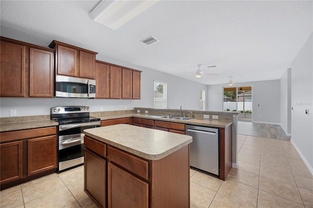 6819 Glenbrook Dr, Lakeland, FL 33811 - kitchen with stainless steel appliances, a sink, a peninsula, and light tile patterned flooring
