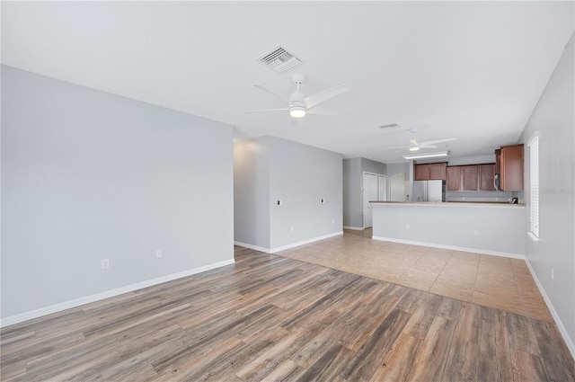 6819 Glenbrook Dr, Lakeland, FL 33811 - unfurnished living room featuring ceiling fan, light wood-style flooring, and baseboards