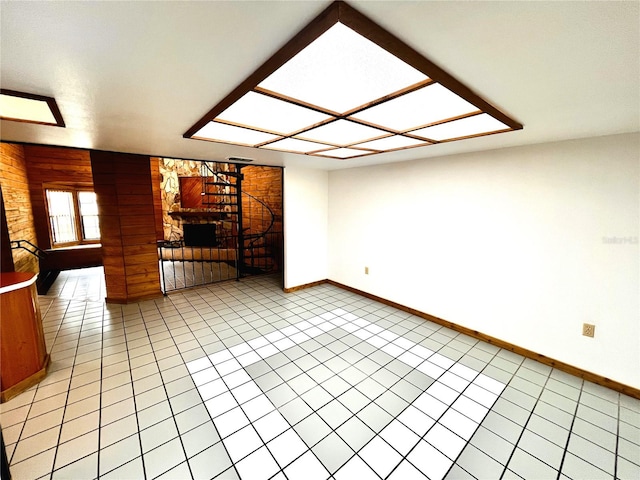 8504 N Campbell Rd, Lakeland, FL 33810 - unfurnished living room featuring baseboards, light tile patterned flooring, and wood walls