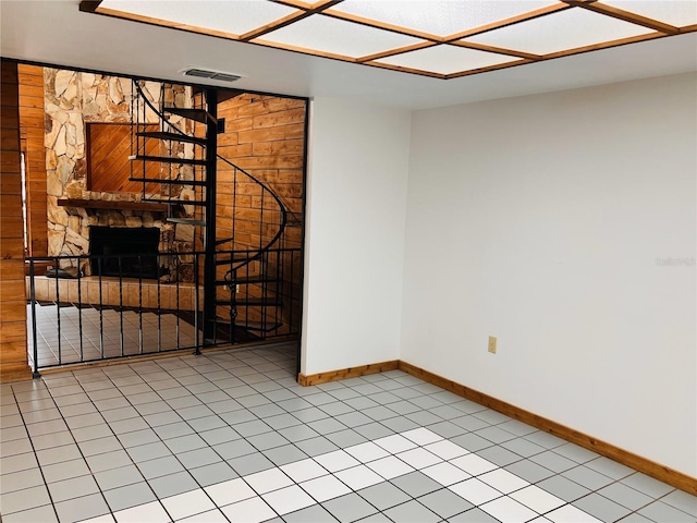 8504 N Campbell Rd, Lakeland, FL 33810 - tiled spare room featuring baseboards, a stone fireplace, and wooden walls