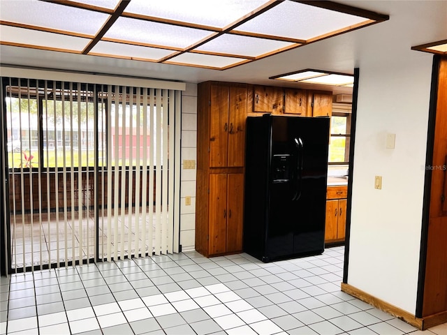 8504 N Campbell Rd, Lakeland, FL 33810 - kitchen with black fridge with ice dispenser, plenty of natural light, brown cabinets, and baseboards