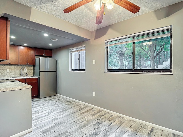 11704 Raintree Village Blvd Unit B, Temple Terrace, FL 33617 - kitchen with freestanding refrigerator, a textured ceiling, ceiling fan, light countertops, and tasteful backsplash