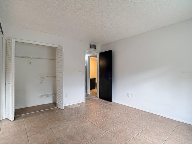 11704 Raintree Village Blvd Unit B, Temple Terrace, FL 33617 - unfurnished bedroom with light tile patterned floors, a textured ceiling, and a closet