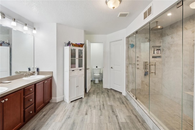 1531 Blue Sky Blvd, Haines City, FL 33844 - bathroom with wood finished floors, a shower stall, double vanity, and a textured ceiling