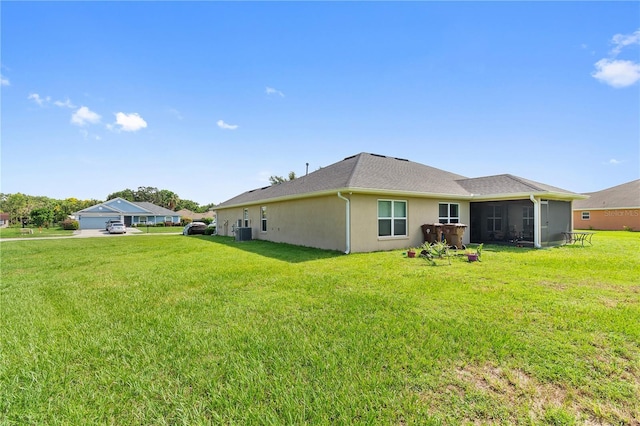 1531 Blue Sky Blvd, Haines City, FL 33844 - rear view of house with stucco siding, a lawn, and a sunroom