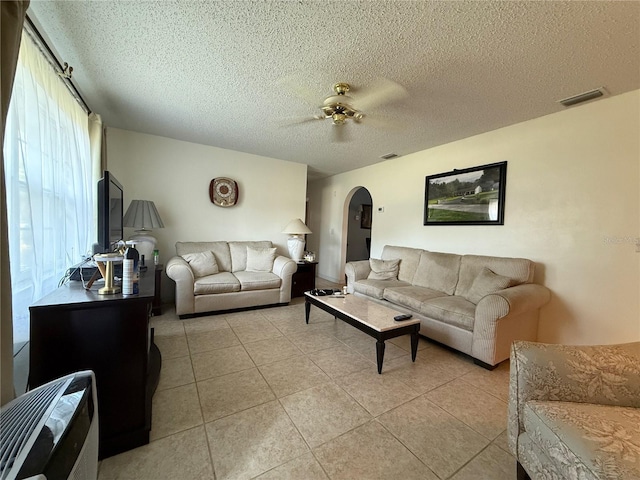 2424 Bates Ave SW, Winter Haven, FL 33880 - living area featuring arched walkways, ceiling fan, light tile patterned floors, and a textured ceiling