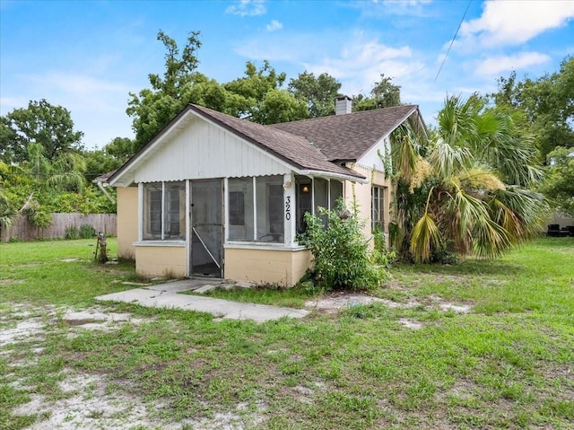 320 W Carver St, Lakeland, FL 33805 - back of house with a sunroom, roof with shingles, a chimney, and concrete block siding