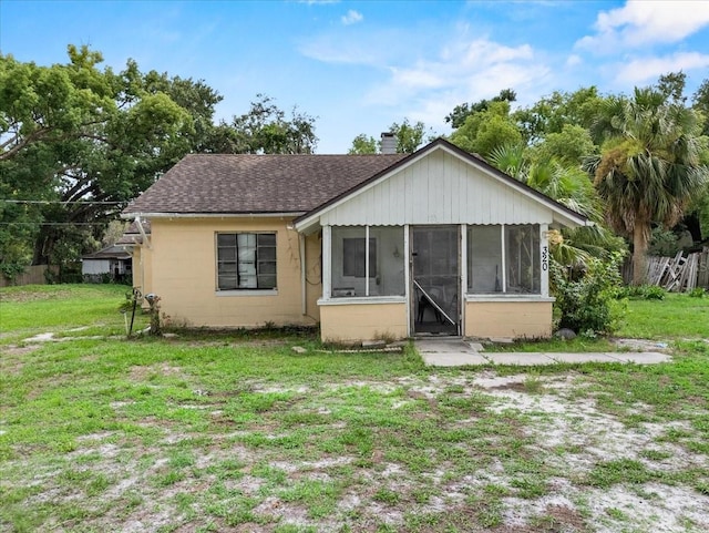 320 W Carver St, Lakeland, FL 33805 - bungalow-style house with concrete block siding, roof with shingles, a sunroom, a front lawn, and a chimney