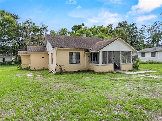 320 W Carver St, Lakeland, FL 33805 - back of house featuring a sunroom, roof with shingles, a chimney, and a yard