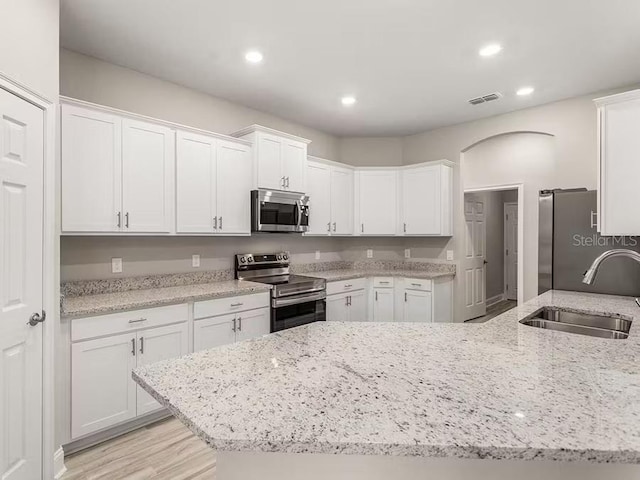 828 Cypress Creek Run, Saint Cloud, FL 34771 - kitchen with stainless steel appliances, a sink, white cabinets, light stone countertops, and recessed lighting