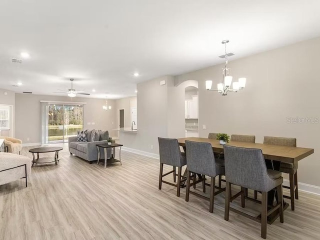 828 Cypress Creek Run, Saint Cloud, FL 34771 - dining area featuring a chandelier, baseboards, light wood-style floors, arched walkways, and recessed lighting