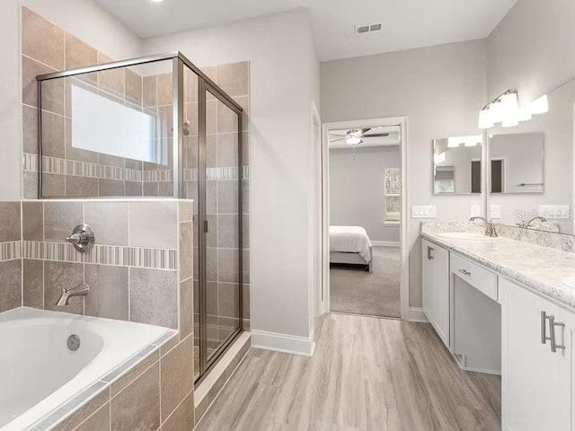 828 Cypress Creek Run, Saint Cloud, FL 34771 - ensuite bathroom with a bath, vanity, a shower stall, and wood finished floors