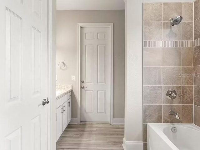828 Cypress Creek Run, Saint Cloud, FL 34771 - bathroom with wood finished floors, vanity, shower / bathtub combination, and baseboards