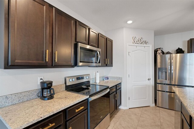 3685 Diving Dove Ln, Bartow, FL 33830 - kitchen featuring appliances with stainless steel finishes, dark brown cabinets, light tile patterned floors, light stone countertops, and recessed lighting