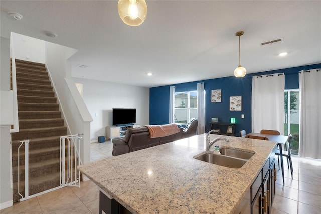 3685 Diving Dove Ln, Bartow, FL 33830 - kitchen featuring decorative light fixtures, light tile patterned flooring, a kitchen island with sink, light stone countertops, and recessed lighting
