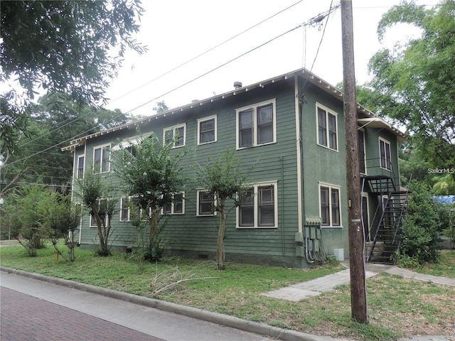 701 E Lime St, Lakeland, FL 33801 - view of side of home with stairs, crawl space, and a yard