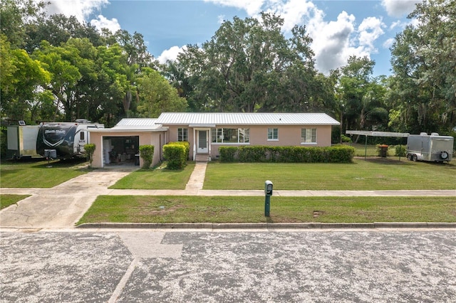 114 Pennsylvania Ave, Wauchula, FL 33873 - single story home with an attached garage, stucco siding, a front lawn, driveway, and a metal roof
