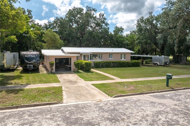 114 Pennsylvania Ave, Wauchula, FL 33873 - ranch-style home featuring stucco siding, a front lawn, an attached garage, driveway, and a metal roof