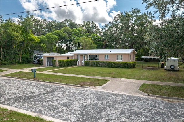114 Pennsylvania Ave, Wauchula, FL 33873 - ranch-style home featuring a front yard, stucco siding, an attached garage, and view of scattered trees