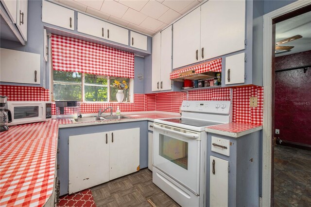 114 Pennsylvania Ave, Wauchula, FL 33873 - kitchen featuring white appliances, light countertops, decorative backsplash, and white cabinetry