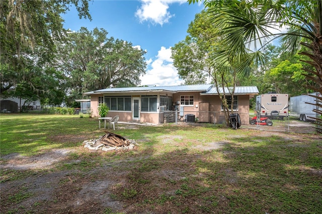 114 Pennsylvania Ave, Wauchula, FL 33873 - back of property with a sunroom, a metal roof, a gate, and stucco siding