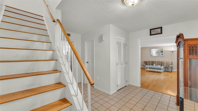1910 Clubhouse Rd, Lakeland, FL 33813 - stairs featuring tile patterned flooring, a textured ceiling, and baseboards