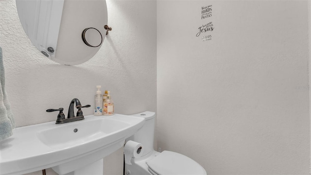 1910 Clubhouse Rd, Lakeland, FL 33813 - half bathroom featuring toilet, a textured wall, and a sink