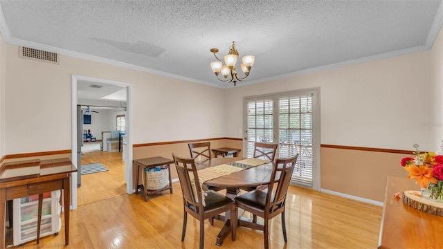 1910 Clubhouse Rd, Lakeland, FL 33813 - dining space with healthy amount of natural light, light wood-type flooring, a textured ceiling, a chandelier, and ornamental molding