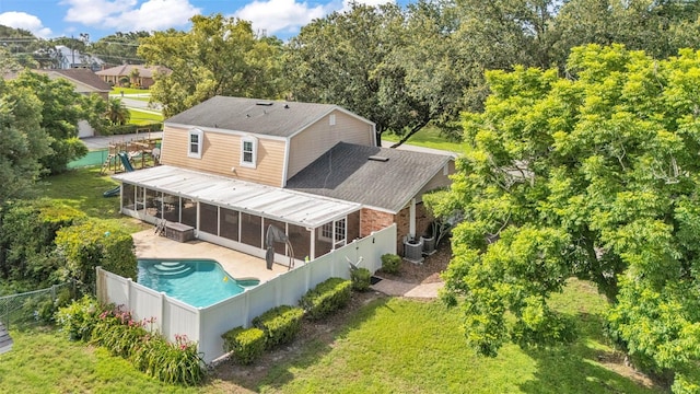 1910 Clubhouse Rd, Lakeland, FL 33813 - back of house featuring a sunroom, a patio, an outdoor pool, central AC, and roof with shingles