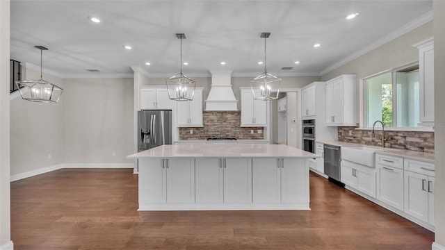1385 Ewell Rd, Lakeland, FL 33811 - kitchen featuring stainless steel appliances, custom range hood, a center island, white cabinets, and recessed lighting