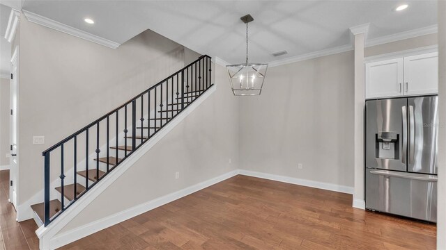 1385 Ewell Rd, Lakeland, FL 33811 - stairway featuring a chandelier, ornamental molding, wood finished floors, and recessed lighting