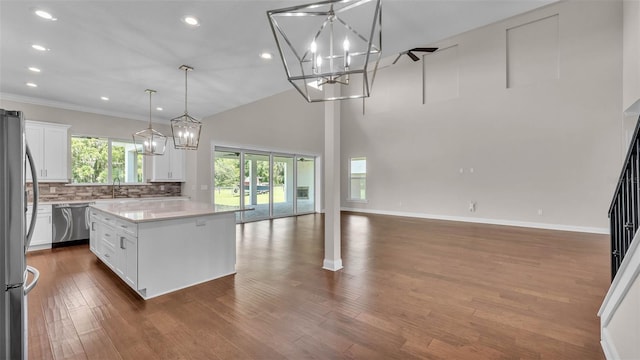 1385 Ewell Rd, Lakeland, FL 33811 - kitchen with appliances with stainless steel finishes, open floor plan, decorative backsplash, light countertops, and a kitchen island