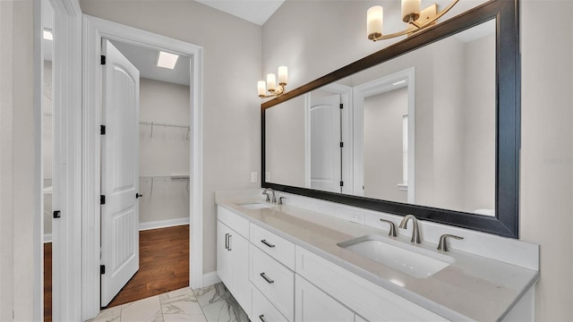 1385 Ewell Rd, Lakeland, FL 33811 - bathroom featuring marble finish flooring, double vanity, a walk in closet, and a chandelier