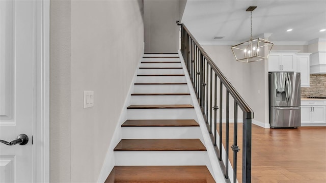 1385 Ewell Rd, Lakeland, FL 33811 - staircase with a chandelier, ornamental molding, wood finished floors, and recessed lighting