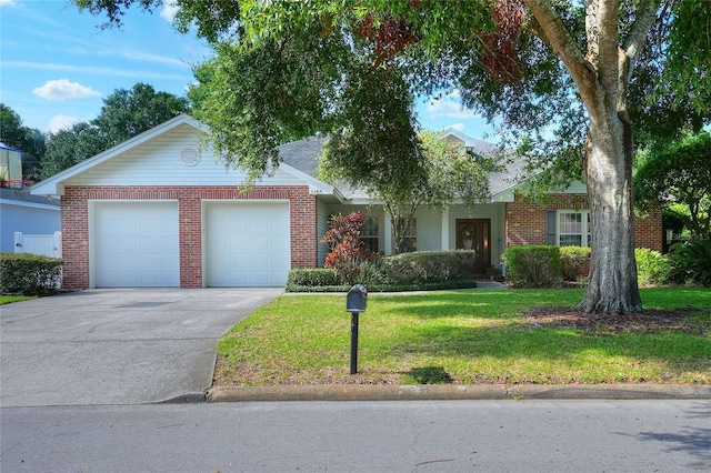 1145 Denton St, Lakeland, FL 33803 - view of front of property featuring a garage, brick siding, a front yard, and concrete driveway