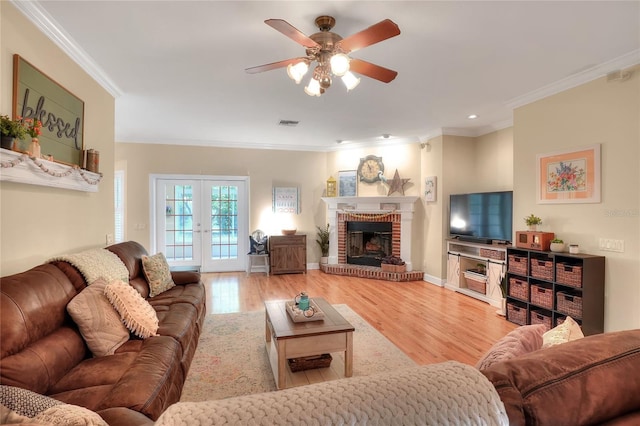 1145 Denton St, Lakeland, FL 33803 - living area featuring a ceiling fan, crown molding, wood finished floors, a brick fireplace, and french doors