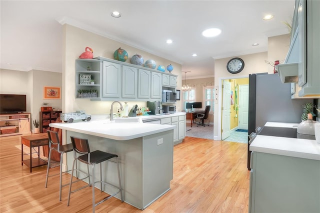 1145 Denton St, Lakeland, FL 33803 - kitchen featuring a peninsula, a breakfast bar, open shelves, ornamental molding, and light wood-style floors