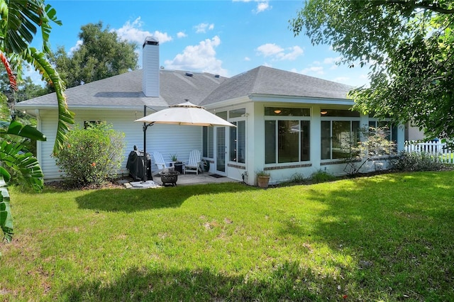 1145 Denton St, Lakeland, FL 33803 - rear view of property with a sunroom, a chimney, a shingled roof, and an outdoor fire pit