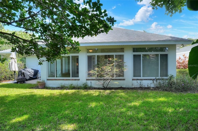 1145 Denton St, Lakeland, FL 33803 - back of property featuring a yard, a shingled roof, and a sunroom