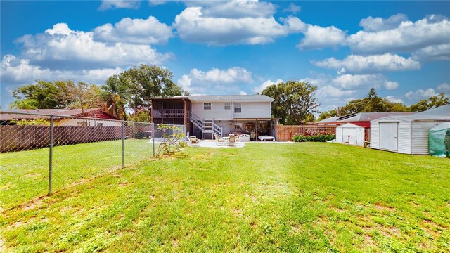 2333 Cheshire Pl, Lakeland, FL 33810 - rear view of house with a sunroom, a shed, a patio, a fenced backyard, and an outdoor fire pit