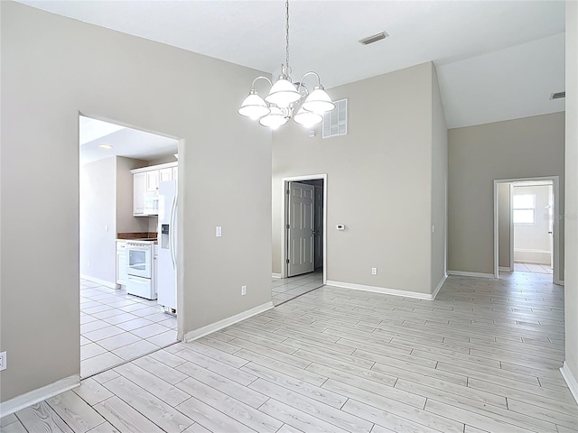 3806 Osprey Pointe Cir, Winter Haven, FL 33884 - empty room with a chandelier, light wood-style floors, and a towering ceiling