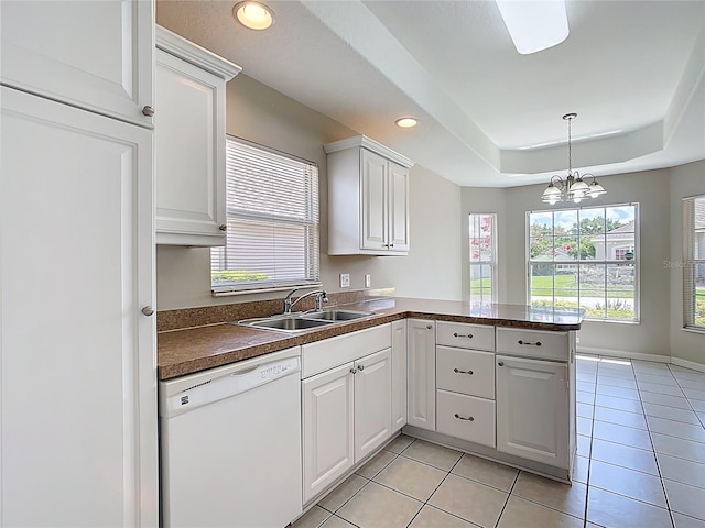 3806 Osprey Pointe Cir, Winter Haven, FL 33884 - kitchen featuring white dishwasher, a peninsula, dark countertops, light tile patterned floors, and plenty of natural light