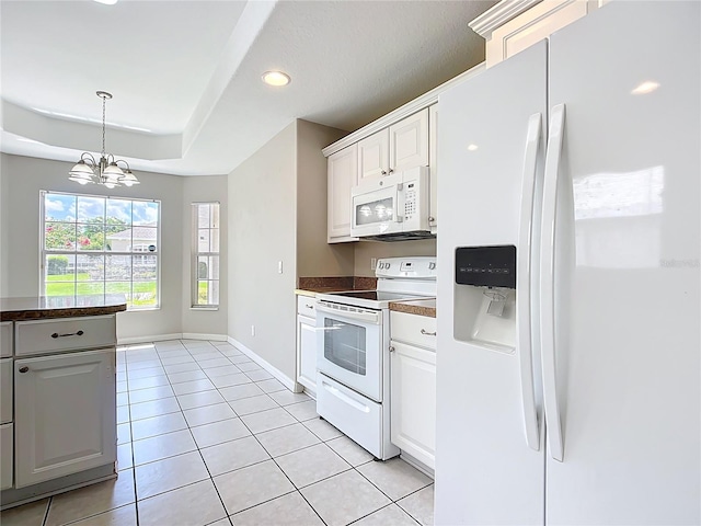 3806 Osprey Pointe Cir, Winter Haven, FL 33884 - kitchen featuring white appliances, light tile patterned floors, a chandelier, dark countertops, and pendant lighting