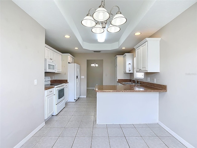 3806 Osprey Pointe Cir, Winter Haven, FL 33884 - kitchen featuring white appliances, a chandelier, a peninsula, white cabinetry, and light tile patterned flooring